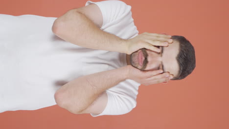 Vertical-video-of-Man-looking-depressed-at-camera.